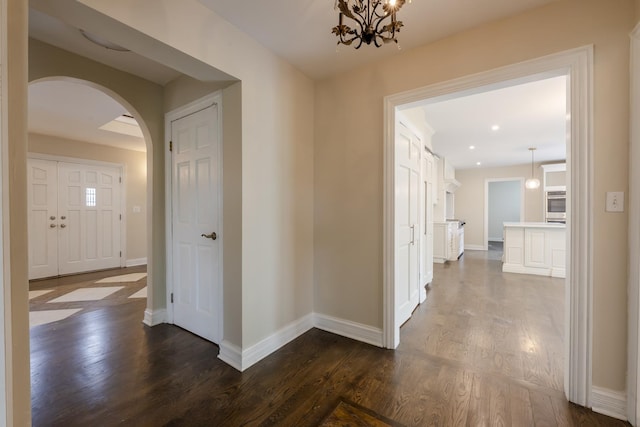 3745 Whirlaway Dr, Northbrook, IL 60062 - hallway with arched walkways, dark wood finished floors, baseboards, and a chandelier