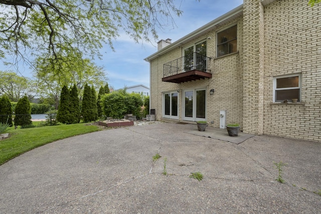3745 Whirlaway Dr, Northbrook, IL 60062 - rear view of property with a balcony, a patio, a chimney, and brick siding