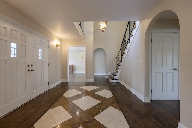 3745 Whirlaway Dr, Northbrook, IL 60062 - entrance foyer with arched walkways, inlaid floor details, baseboards, and dark wood-style floors