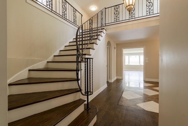 3745 Whirlaway Dr, Northbrook, IL 60062 - stairs with arched walkways, baseboards, a high ceiling, and wood finished floors