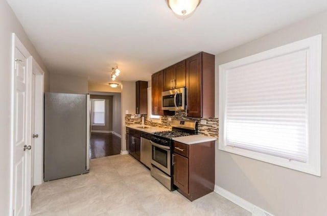 9032 S University Ave, Chicago, IL 60619 - kitchen with appliances with stainless steel finishes, a sink, light countertops, tasteful backsplash, and baseboards