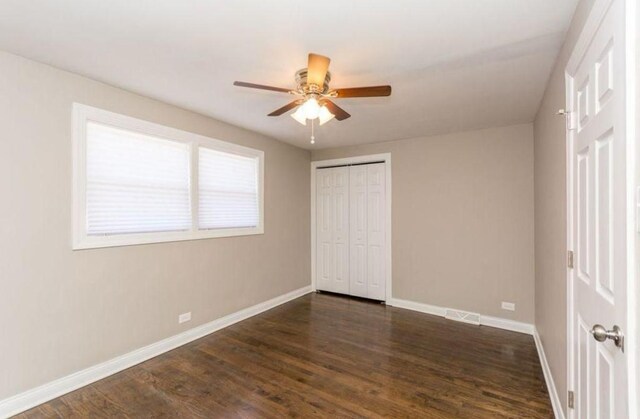 9032 S University Ave, Chicago, IL 60619 - unfurnished bedroom featuring baseboards, dark wood-type flooring, a closet, and ceiling fan