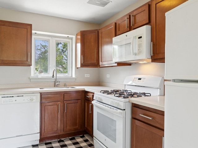 524 Michigan Ave Unit 3N, Evanston, IL 60202 - kitchen with white appliances, a sink, light countertops, tile patterned floors, and brown cabinetry