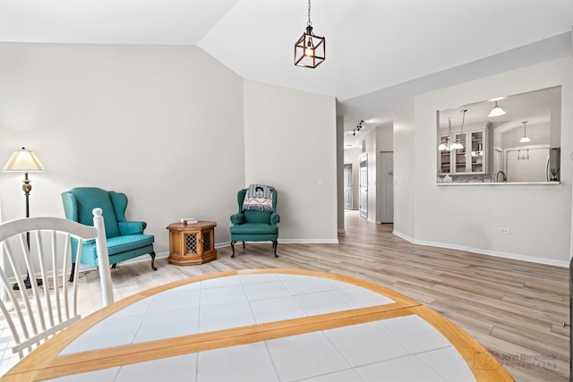 1553 Catalina Ln, Aurora, IL 60504 - living area featuring wood finished floors, vaulted ceiling, a chandelier, and baseboards