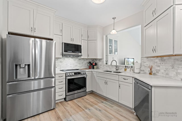 1553 Catalina Ln, Aurora, IL 60504 - kitchen featuring appliances with stainless steel finishes, a sink, decorative backsplash, and light wood-style flooring