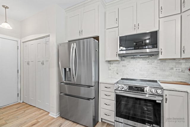 1553 Catalina Ln, Aurora, IL 60504 - kitchen featuring appliances with stainless steel finishes, light countertops, light wood-style flooring, decorative backsplash, and white cabinets