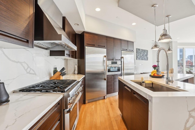 650 N Morgan St Unit 303, Chicago, IL 60642 - kitchen with premium appliances, wall chimney range hood, a sink, recessed lighting, and light wood finished floors