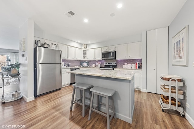 445 N Park Blvd Unit 3D, Glen Ellyn, IL 60137 - kitchen with stainless steel appliances, white cabinetry, light wood-style floors, tasteful backsplash, and recessed lighting