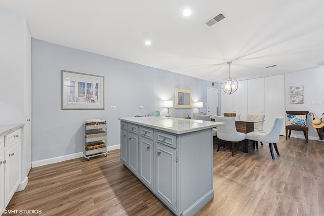 445 N Park Blvd Unit 3D, Glen Ellyn, IL 60137 - kitchen with light wood finished floors, a center island, decorative light fixtures, light stone countertops, and baseboards