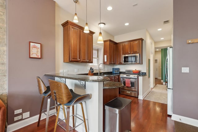 1626 S Morgan St Unit 2, Chicago, IL 60608 - kitchen with appliances with stainless steel finishes, a peninsula, a kitchen breakfast bar, dark wood finished floors, and baseboards