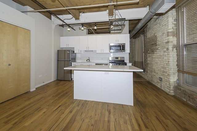 420 S Clinton St Unit 408A, Chicago, IL 60607 - kitchen with stainless steel appliances, light countertops, brick wall, dark wood-style floors, and white cabinetry