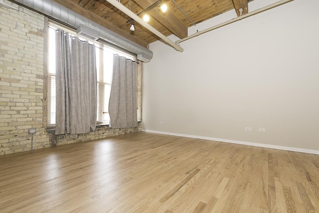 420 S Clinton St Unit 408A, Chicago, IL 60607 - unfurnished room featuring wood ceiling with exposed beams, wood finished floors, brick wall, and rail lighting