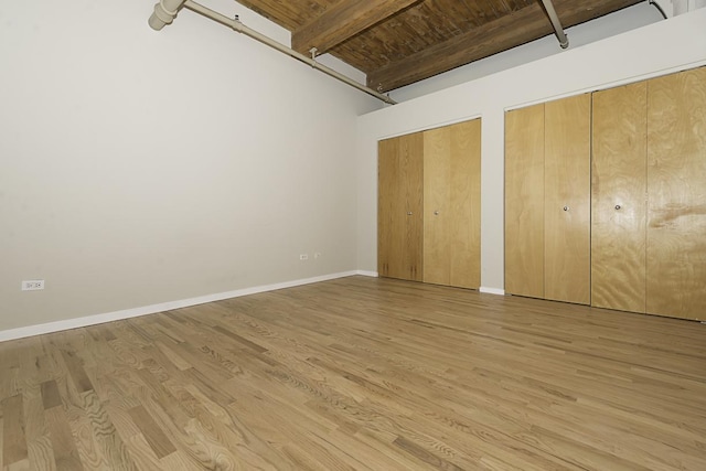 420 S Clinton St Unit 408A, Chicago, IL 60607 - unfurnished bedroom featuring light wood-style floors, multiple closets, baseboards, and beam ceiling