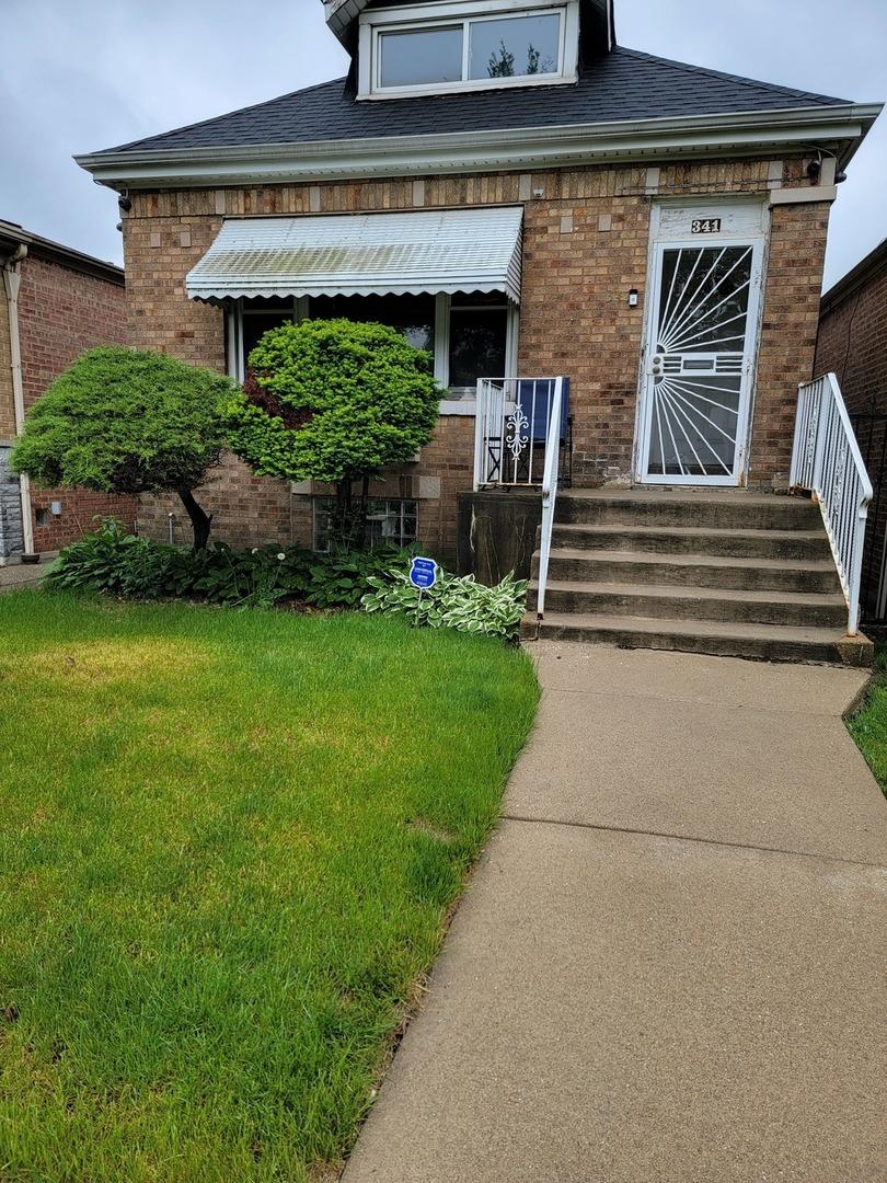 341 W 99th Pl, Chicago, IL 60628 - view of front of property featuring brick siding, a front yard, and roof with shingles