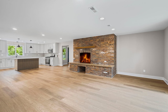 18908 E Louise Dr, Lansing, IL 60438 - unfurnished living room featuring light wood-style floors, baseboards, recessed lighting, and a sink