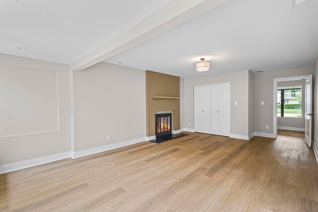 18908 E Louise Dr, Lansing, IL 60438 - unfurnished living room featuring a large fireplace, light wood-style floors, and baseboards