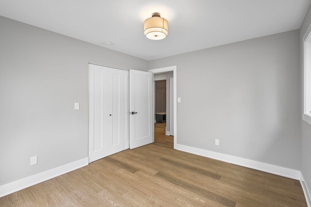 18908 E Louise Dr, Lansing, IL 60438 - unfurnished bedroom featuring baseboards, a closet, and light wood finished floors