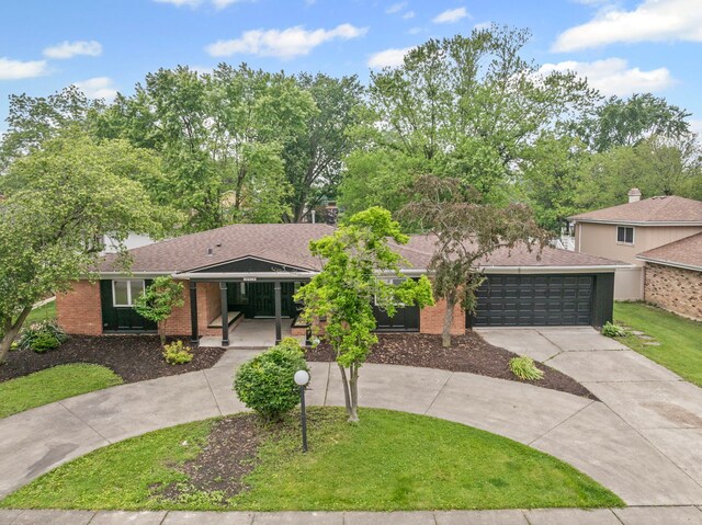 18908 E Louise Dr, Lansing, IL 60438 - view of front of property featuring curved driveway, an attached garage, covered porch, a front lawn, and brick siding