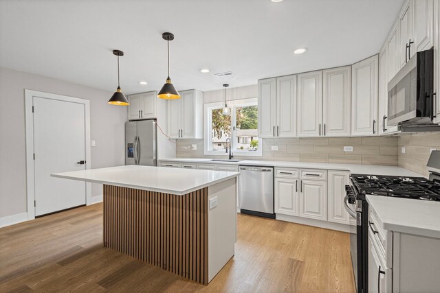 18908 E Louise Dr, Lansing, IL 60438 - kitchen featuring appliances with stainless steel finishes, a sink, light wood-type flooring, backsplash, and recessed lighting