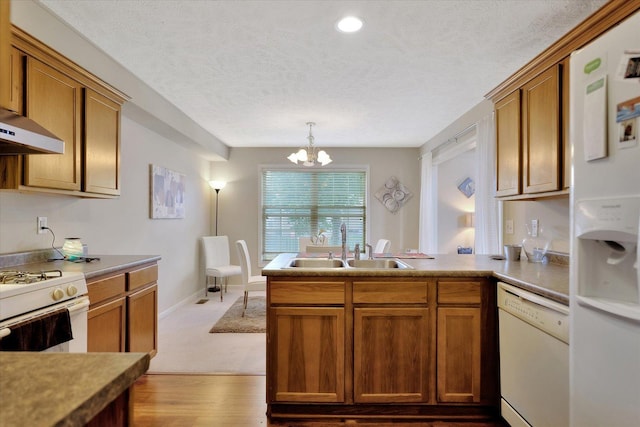 3911 Summer Sage Ct, Champaign, IL 61822 - kitchen featuring white appliances, a peninsula, a textured ceiling, a chandelier, and brown cabinetry