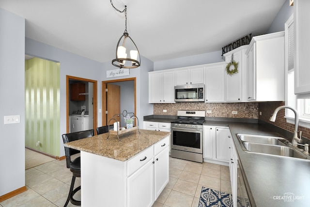 25411 W Juniper Ct, Plainfield, IL 60585 - kitchen featuring appliances with stainless steel finishes, tasteful backsplash, light tile patterned flooring, and washing machine and dryer