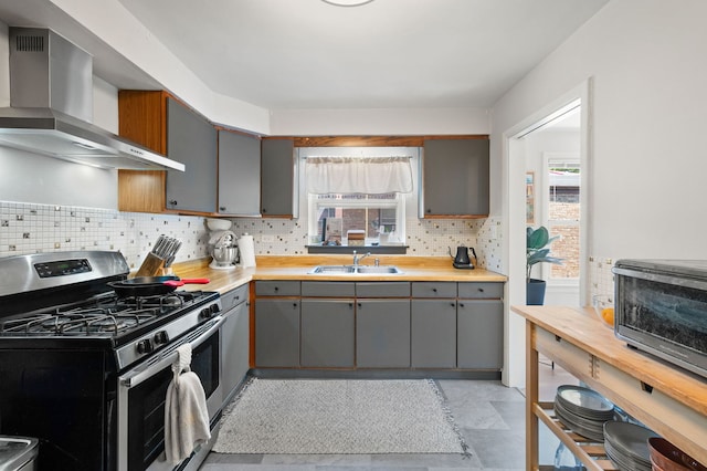 318 Custer Ave, Evanston, IL 60202 - kitchen featuring stainless steel gas range oven, wall chimney exhaust hood, gray cabinets, a sink, and decorative backsplash