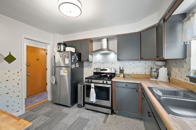 318 Custer Ave, Evanston, IL 60202 - kitchen with appliances with stainless steel finishes, wall chimney exhaust hood, light countertops, a sink, and decorative backsplash
