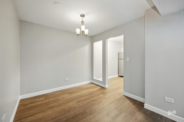 5500 Carriageway Dr Unit 213, Rolling Meadows, IL 60008 - empty room featuring a chandelier, baseboards, wood finished floors, and a smoke detector