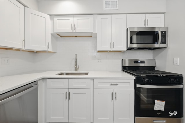 5500 Carriageway Dr Unit 213, Rolling Meadows, IL 60008 - kitchen with stainless steel appliances, a sink, white cabinets, light countertops, and tasteful backsplash