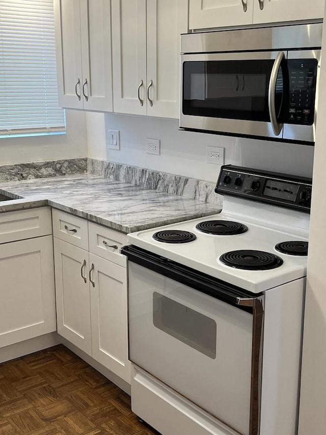 7 Garden Dr Unit 7, La Grange Park, IL 60526 - kitchen with white electric stove, stainless steel microwave, white cabinets, and light stone counters