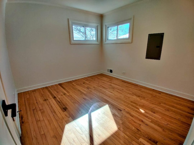 7726 N Harlem Ave, Niles, IL 60714 - unfurnished room with electric panel, crown molding, light wood finished floors, and baseboards