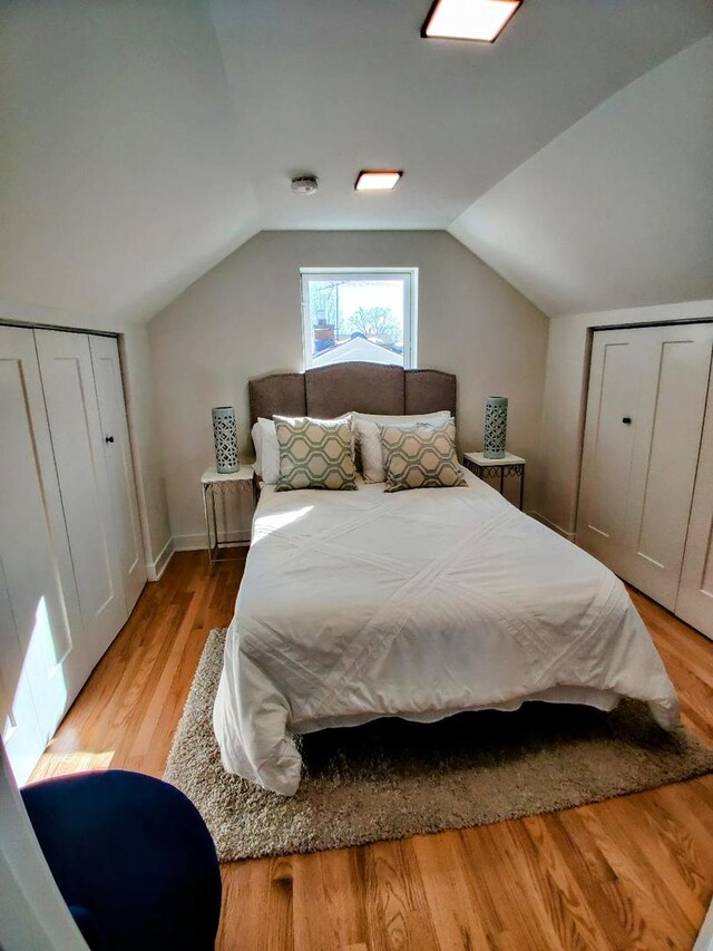 7726 N Harlem Ave, Niles, IL 60714 - bedroom with light wood-type flooring, vaulted ceiling, a closet, and baseboards