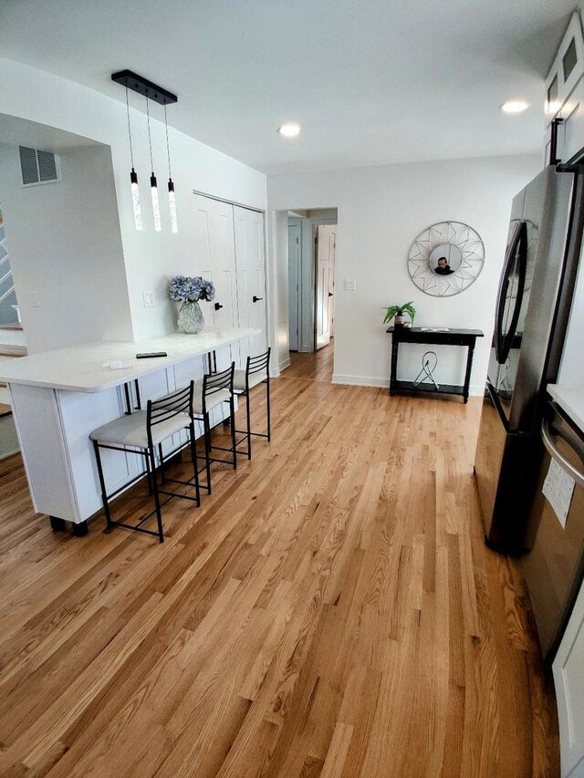 7726 N Harlem Ave, Niles, IL 60714 - kitchen featuring light wood-style floors, freestanding refrigerator, decorative light fixtures, light countertops, and recessed lighting