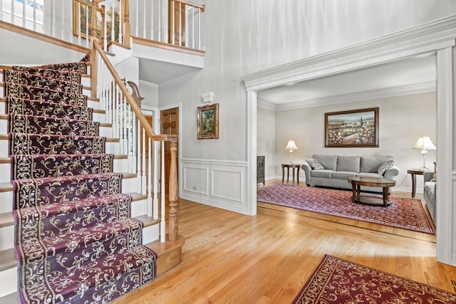 1514 Triple Crown Ct, Saint Charles, IL 60174 - staircase with wood finished floors, crown molding, a wainscoted wall, and a high ceiling