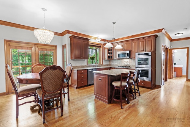 1514 Triple Crown Ct, Saint Charles, IL 60174 - kitchen with appliances with stainless steel finishes, ornamental molding, a chandelier, a kitchen island, and a breakfast bar area