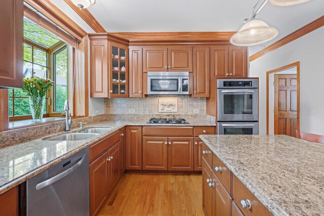 1514 Triple Crown Ct, Saint Charles, IL 60174 - kitchen with appliances with stainless steel finishes, a sink, ornamental molding, brown cabinetry, and light stone countertops
