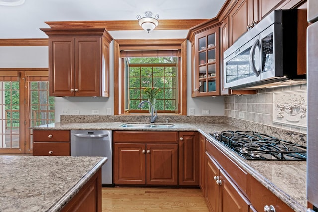 1514 Triple Crown Ct, Saint Charles, IL 60174 - kitchen featuring appliances with stainless steel finishes, a sink, light wood-style floors, glass insert cabinets, and brown cabinetry