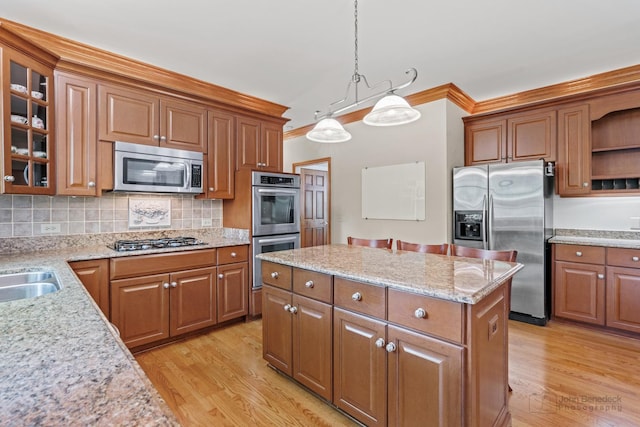 1514 Triple Crown Ct, Saint Charles, IL 60174 - kitchen featuring appliances with stainless steel finishes, ornamental molding, light wood-type flooring, brown cabinets, and a center island