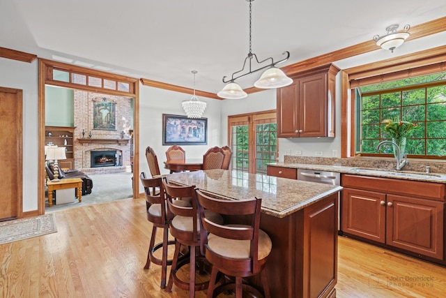 1514 Triple Crown Ct, Saint Charles, IL 60174 - kitchen with a sink, a center island, light stone counters, a fireplace, and crown molding