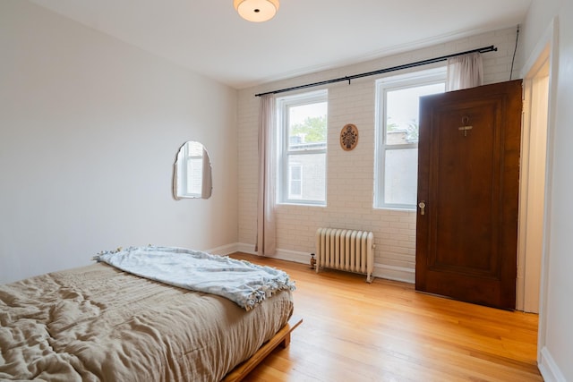 6652 N Glenwood Ave Unit 3N, Chicago, IL 60626 - bedroom with radiator heating unit, light wood-style floors, baseboards, and brick wall