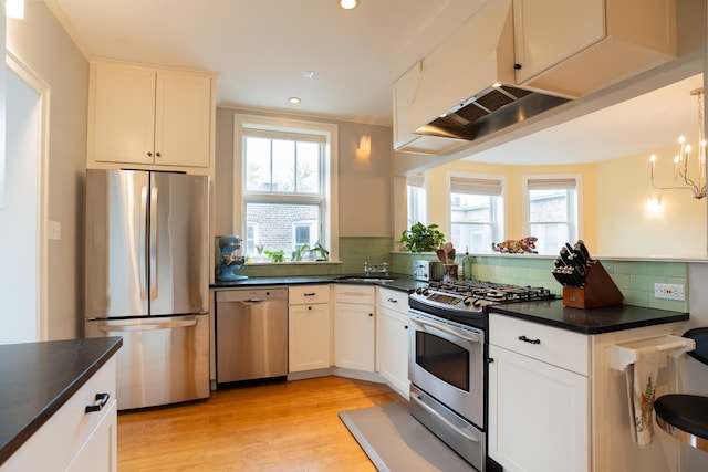 6652 N Glenwood Ave Unit 3N, Chicago, IL 60626 - kitchen featuring appliances with stainless steel finishes, dark countertops, a sink, light wood finished floors, and backsplash