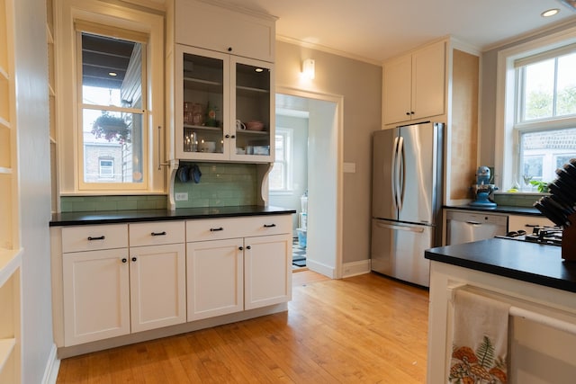6652 N Glenwood Ave Unit 3N, Chicago, IL 60626 - kitchen featuring stainless steel appliances, light wood-type flooring, dark countertops, decorative backsplash, and baseboards