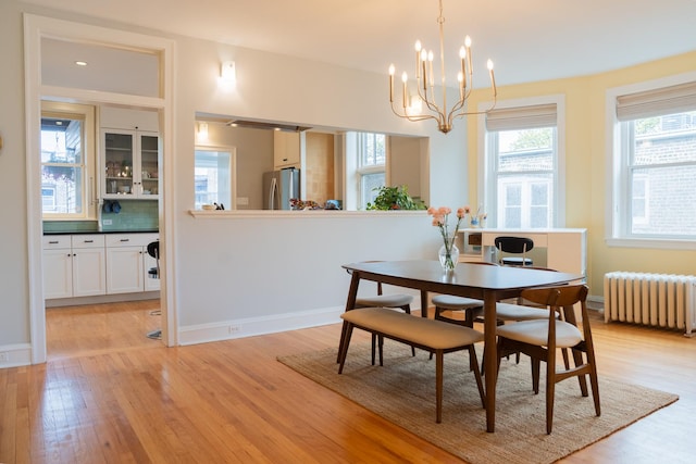 6652 N Glenwood Ave Unit 3N, Chicago, IL 60626 - dining space featuring radiator, light wood-type flooring, a chandelier, and baseboards