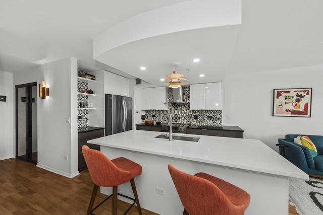 1640 Maple Ave Unit 505, Evanston, IL 60201 - kitchen with modern cabinets, a sink, freestanding refrigerator, wall chimney exhaust hood, and white cabinetry
