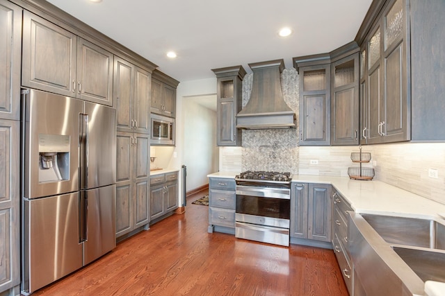 2907 Camden Dr, West Chicago, IL 60185 - kitchen featuring stainless steel appliances, custom range hood, decorative backsplash, dark wood finished floors, and glass insert cabinets