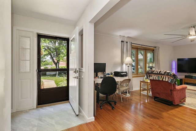home office featuring healthy amount of natural light, baseboards, light wood-style floors, and a ceiling fan