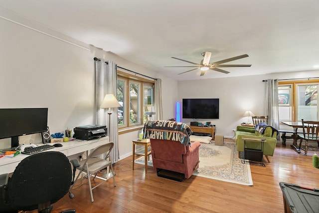 living area featuring light wood-style floors, an office area, and ceiling fan