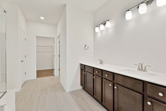 3214 Lincoln Prairie Blvd, Aurora, IL 60503 - bathroom with double vanity, a walk in closet, baseboards, and tile patterned floors