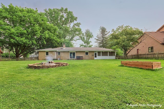 34942 N Gogol Ave, Ingleside, IL 60041 - back of property featuring a fire pit, a fenced backyard, brick siding, and a chimney