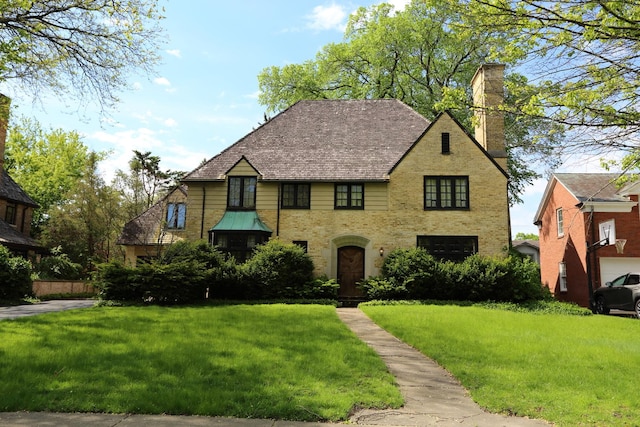 506 Greenwood Ave, Kenilworth, IL 60043 - english style home featuring a chimney, a front yard, and brick siding